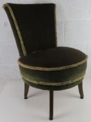 A fireside chair upholstered in green velvet.