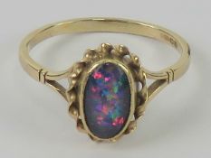 A contemporary 9ct gold opal doublet ring, the central oval cabachon having good multi colour fire,