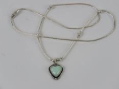 A 925 silver and opal pendant in the form of a heart on a Native American style beaded chain.