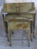 A nest of three onyx topped brass framed tables c1960s, each raise don wheels, 50,