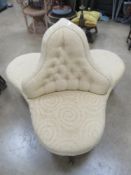 A triform chair having three low seats raised over turned legs terminating in brass castors,