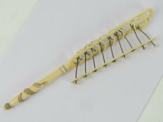 A 19thC ivory rattle having carved serpent design to handle and measuring 25.5cm in length.