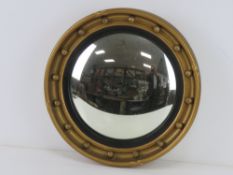 A convex circular wall mirror having black and gold painted frame, 41.5cm dia.