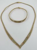 A 9ct gold tri-colour suite of jewellery comprising necklace and bracelet having bark effect