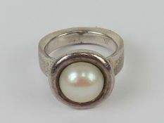 A silver and pearl ring, stamped 925 with makers mark GE, size N.