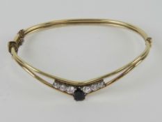 A vintage sapphire and white stone bangle, stamped very indistinctly (?)5 M(??) 9ct?,