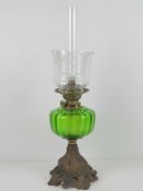 An oil lamp having green glass reservoir, etched glass shade, with chimney.