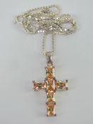 A silver crucifix set with peach coloured stones, on box link silver chain, pendant measuring 2.