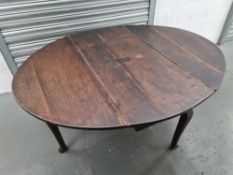 An oval drop leaf table raised over shaped legs, 5ft x 4ft x 2ft 4