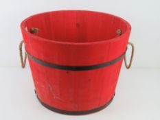 A Christmas tree bucket painted red and having metal stand concealed within, 44.5cm dia.