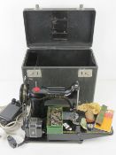 A Singer sewing machine in original box together with Singer replacement parts including needles in