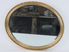 A contemporary oval bevel edged wall mir