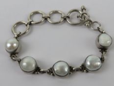 A silver and pearl bracelet having T bar