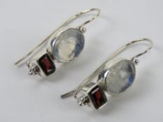 A pair of silver moonstone and garnet ea