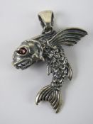 A flying fish pendant having red stone e