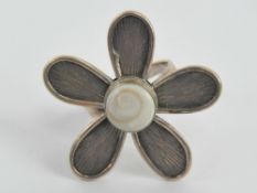 A silver ring in the form of a large flo