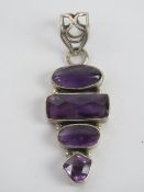 A silver and amethyst pendant having thr