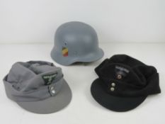 A reproduction WWII German M42 helmet. Together with two reproduction German Ski caps.