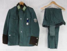 A reproduction WWII German Combat Jacket with rank and medal, with breeches.