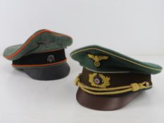 Nine German Posters together with two reproduction WWII German Officers Caps, both sized 60.