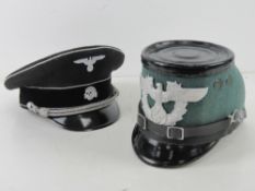 A replica Police helmet, together with a reproduction WWII German SS Visor cap.