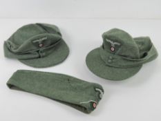 A reproduction WWII German side cap together with two ski hats.