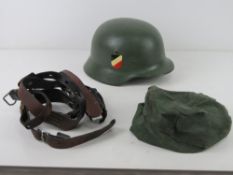 A pair of German 'Y' straps together with a reproduction German Army helmet and helmet cover.