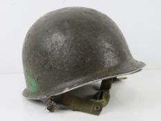 A US Vietnam era helmet with liner.