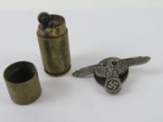 A Trench Art brass lighter. Together with a German SS Eagle badge.