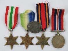 Four WWII British medals together with one Dog tag.