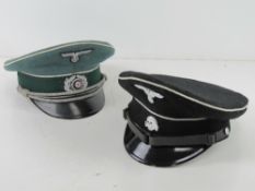 A replica German Army Officers visor cap together with a reproduction WWII German SS visor cap.