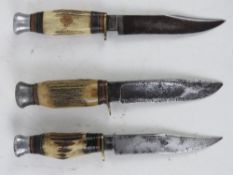 Three fighting knives having antler handles.