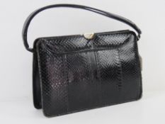 A vintage black leather reptile skin han