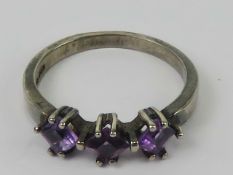 A silver three stone square cut amethyst
