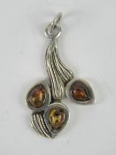 A Baltic amber floral pendant, no appare