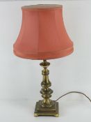 A brass table lamp having pink silk shad