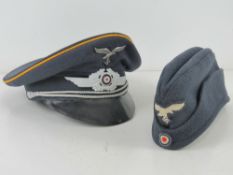 A reproduction WWII German visor cap, together with a reproduction WWII German side cap.