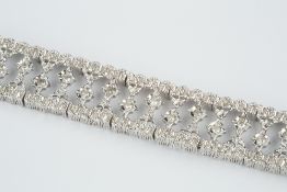 Diamond set panel bracelet designed as a line of articulated openwork panels with central star