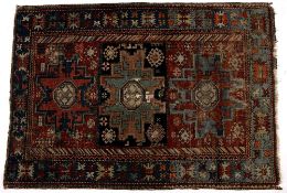 Caucasian polychrome rug with three stylised geometric panels and blue border, 156cm x 107cm