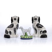 Pair of Staffordshire spaniels with black painted decoration, 27cm high and a single smaller model