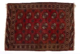 Bokhara red ground rug with three rows of stylised elephant foot designs within a foliate border