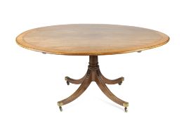 Mahogany and crossbanded oval dining/breakfast table on splayed supports with brass castors, ex