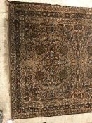 A Persian rug, the central panel set with all-over floral design in brown and cream, within a