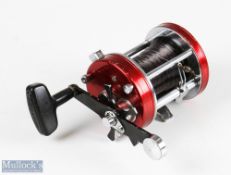 ABU Ambassadeur 7000 multiplier reel stamped 821000 to base, finished in red, runs smooth, signs