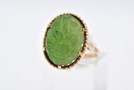 A 9CT GOLD, CARVED NEPHRITE CAMEO RING, of an oval form with a carved floral design, beaded