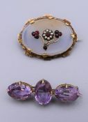 A Victorian garnet and seed pearl set brooch and an amethyst set brooch. The former 4.25 cm wide.