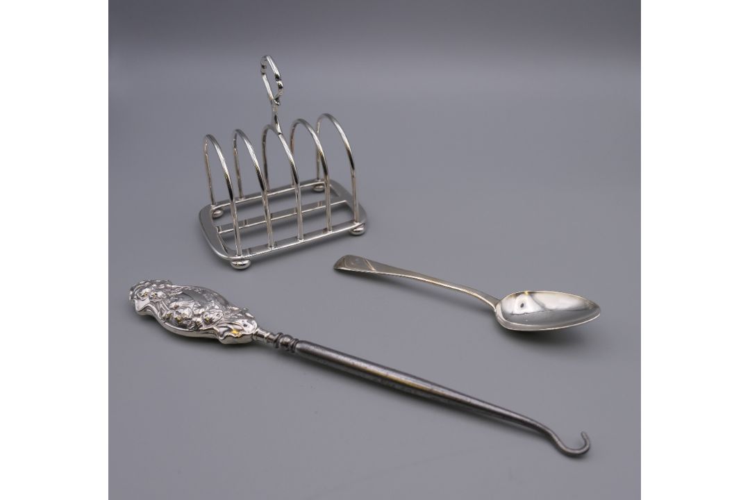 An Asprey silver toast rack , a silver handled button hook and a silver teaspoon. - Image 1 of 15