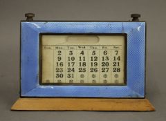An enamel decorated silver desk calendar. 13 cm high.