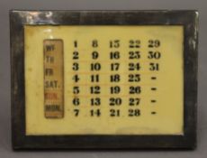 A silver desk calendar. 15 cm wide.