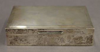 A silver cigarette box. 14.25 cm wide. 12.1 troy ounces total weight.